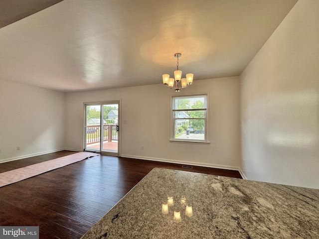 225 N New St, Dover, DE 19904 - empty room with healthy amount of natural light, dark wood-style flooring, and a chandelier