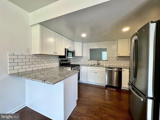 225 N New St, Dover, DE 19904 - kitchen with stainless steel appliances, a peninsula, white cabinetry, tasteful backsplash, and recessed lighting