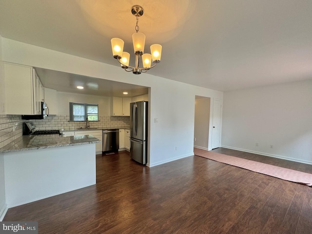 225 N New St, Dover, DE 19904 - kitchen with stainless steel appliances, dark wood finished floors, open floor plan, light stone countertops, and a chandelier