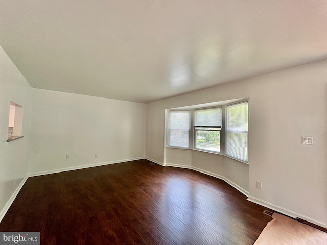 225 N New St, Dover, DE 19904 - spare room featuring dark wood-type flooring and baseboards