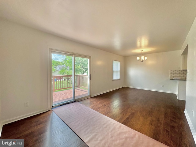 225 N New St, Dover, DE 19904 - spare room featuring a chandelier and dark wood-style floors