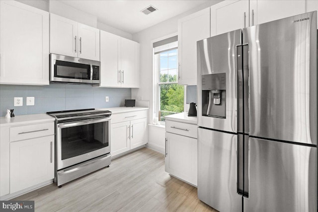 110 Chevy Chase St Unit 301, Gaithersburg, MD 20878 - kitchen with appliances with stainless steel finishes, white cabinets, light countertops, and decorative backsplash