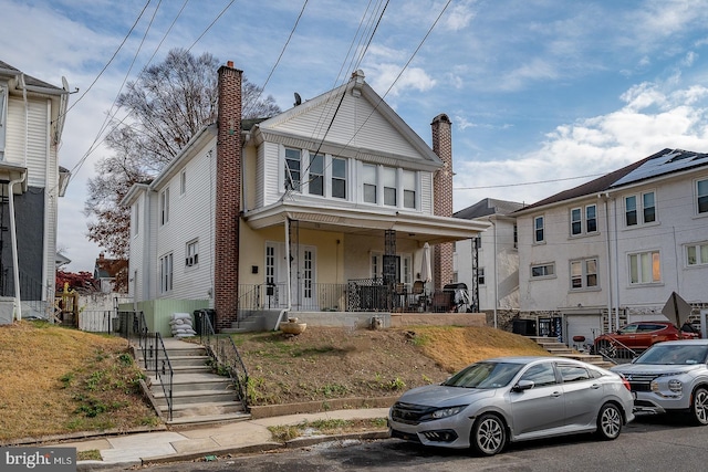 17 Elm Ave, Upper Darby, PA 19082 - view of front of house with covered porch, brick siding, and a chimney