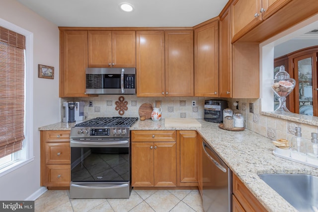 606 Yorkshire Ct, Sewell, NJ 08080 - kitchen featuring appliances with stainless steel finishes, backsplash, light tile patterned flooring, baseboards, and light stone countertops