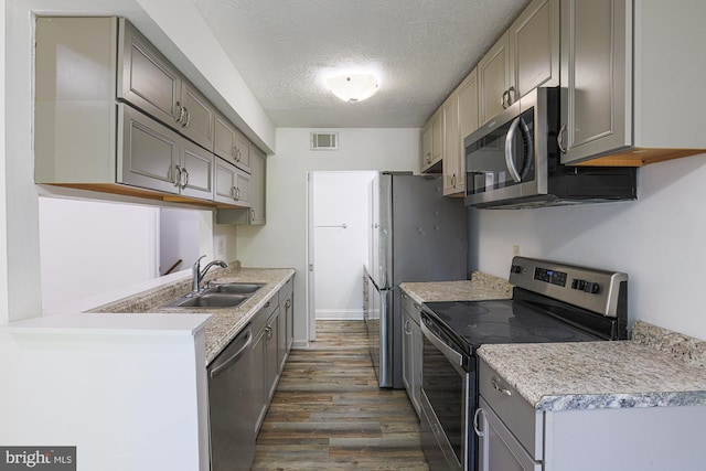 15 Woodenbridge Ct Unit C, Reisterstown, MD 21136 - kitchen featuring appliances with stainless steel finishes, gray cabinetry, dark wood-style floors, a textured ceiling, and light countertops