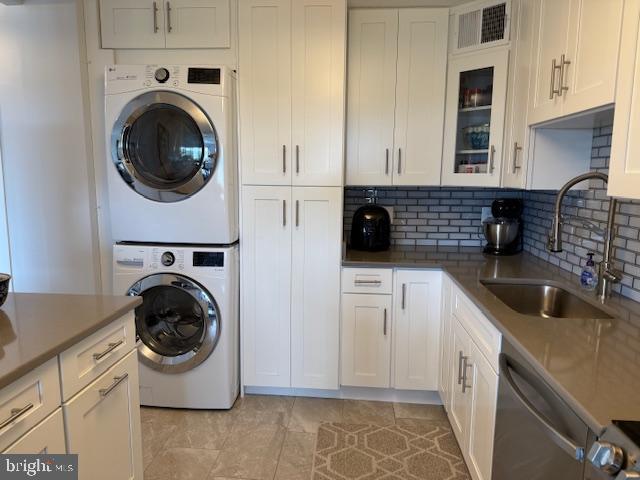309 Yoakum Pkwy Unit 1809, Alexandria, VA 22304 - laundry area with stacked washer and clothes dryer and light tile patterned flooring