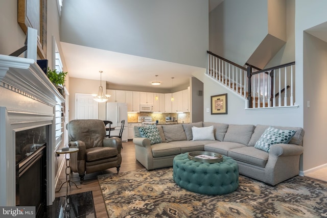 102 Warwick Way N, Wales, PA 19454 - living area featuring a towering ceiling, wood finished floors, stairs, and a fireplace