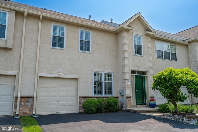 102 Warwick Way N, Wales, PA 19454 - townhome / multi-family property with stucco siding, asphalt driveway, stone siding, and an attached garage