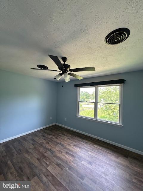 121 Defense Ct, Hedgesville, WV 25427 - unfurnished room with a textured ceiling, dark wood-style flooring, baseboards, and a ceiling fan