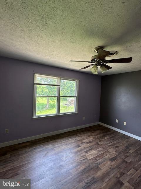 121 Defense Ct, Hedgesville, WV 25427 - unfurnished room featuring a textured ceiling, dark wood finished floors, a ceiling fan, and baseboards