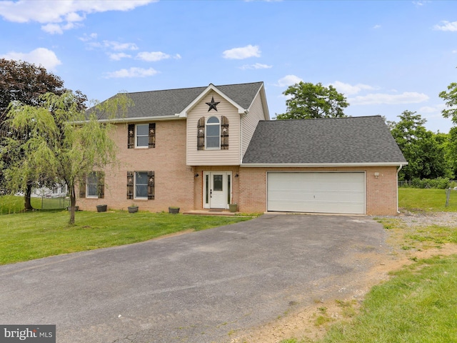 121 Defense Ct, Hedgesville, WV 25427 - view of front of house with asphalt driveway, an attached garage, a front lawn, roof with shingles, and brick siding