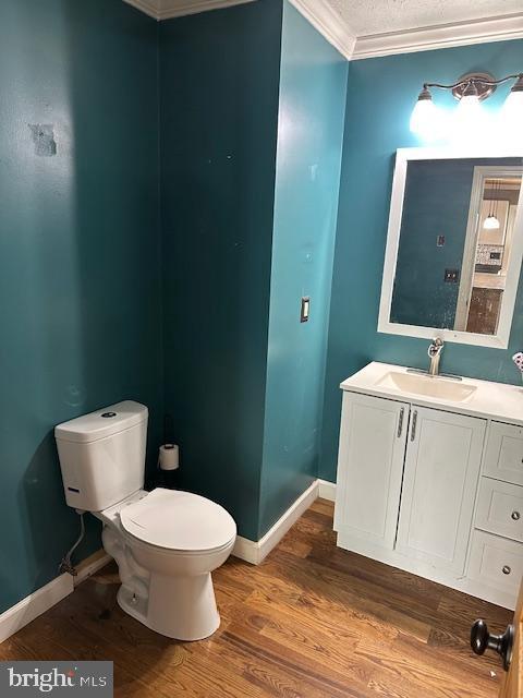 121 Defense Ct, Hedgesville, WV 25427 - bathroom with ornamental molding, toilet, vanity, wood finished floors, and baseboards