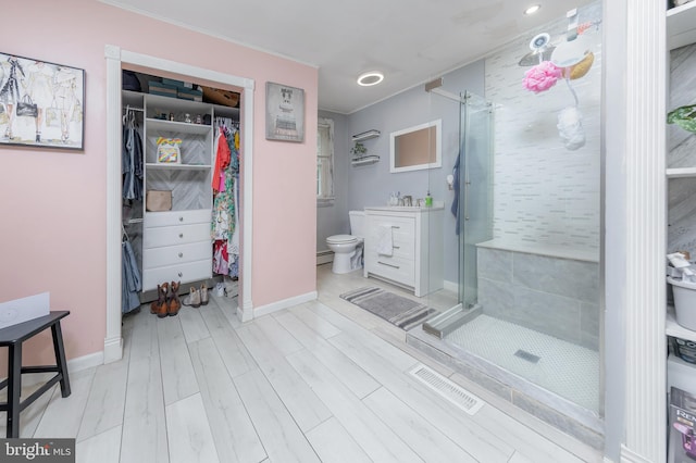 535 Friesburg Aldine, Elmer, NJ 08318 - bathroom featuring a shower stall, vanity, a walk in closet, crown molding, and wood finished floors