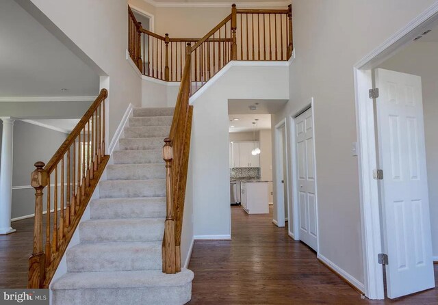 6215 Erland Way, Lanham, MD 20706 - stairs with wood finished floors, decorative columns, baseboards, a towering ceiling, and ornamental molding