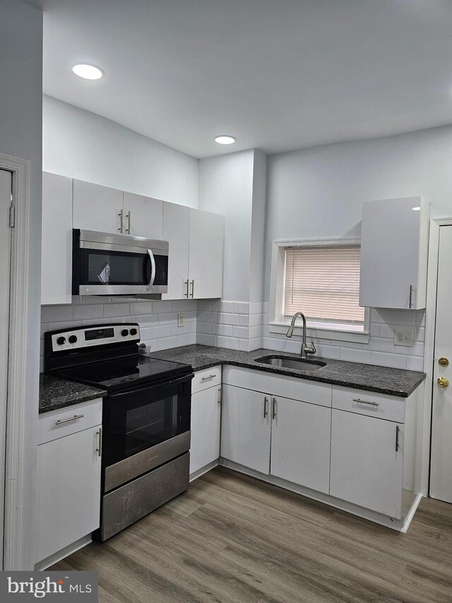 2249 Kennedy St, Philadelphia, PA 19137 - kitchen featuring stainless steel appliances, a sink, tasteful backsplash, wood finished floors, and recessed lighting