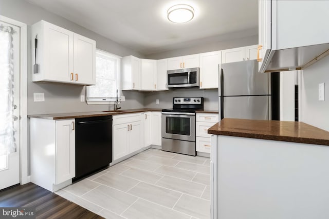 8892 Mckinley Ct, Hummelstown, PA 17036 - kitchen featuring appliances with stainless steel finishes, dark countertops, white cabinets, and a sink