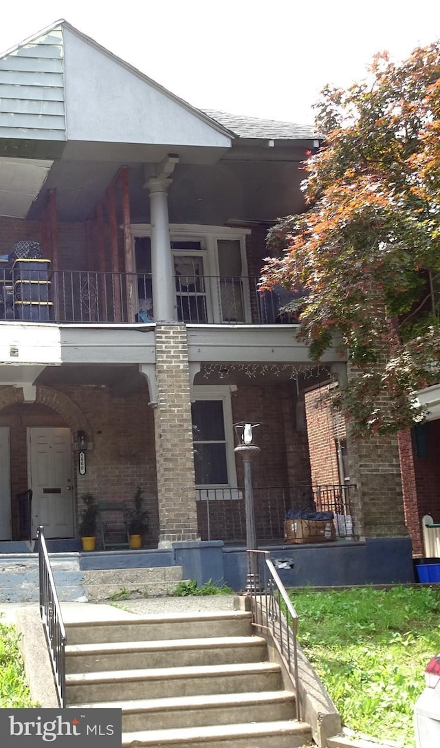 5400 Angora Ter, Philadelphia, PA 19143 - view of front facade with brick siding, covered porch, and a balcony