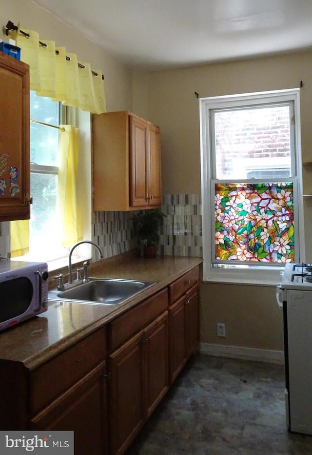5400 Angora Ter, Philadelphia, PA 19143 - kitchen with stainless steel microwave, a sink, healthy amount of natural light, and decorative backsplash