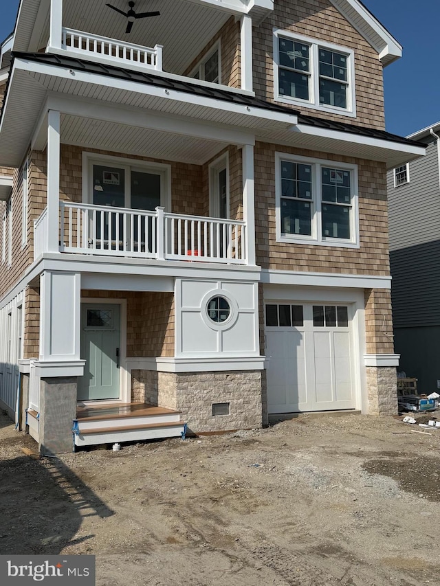 11 E 13th, Long Beach Township, NJ 08008 - view of front of property featuring a balcony, a garage, dirt driveway, and stone siding