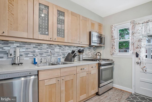 7215 Conley St, Baltimore, MD 21224 - kitchen with stainless steel appliances, light brown cabinetry, a sink, baseboards, and backsplash