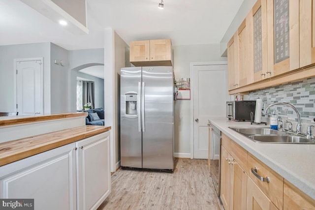 7215 Conley St, Baltimore, MD 21224 - kitchen with stainless steel appliances, a sink, arched walkways, light wood-style flooring, and light brown cabinetry