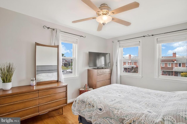 7215 Conley St, Baltimore, MD 21224 - bedroom with wood finished floors, multiple windows, ceiling fan, and baseboards