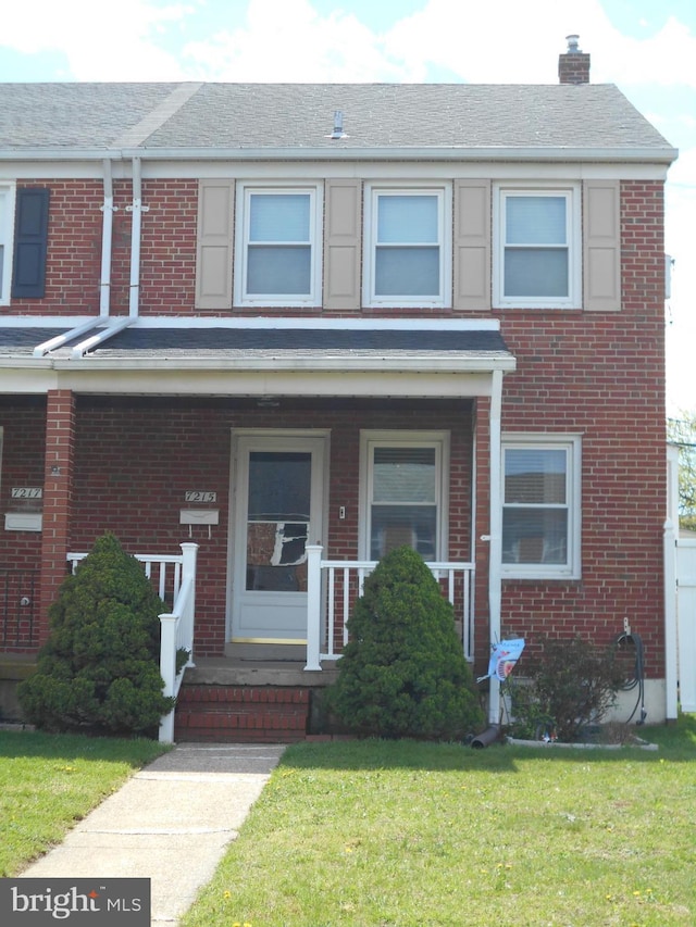 7215 Conley St, Baltimore, MD 21224 - view of property with brick siding, a chimney, a front yard, and a porch