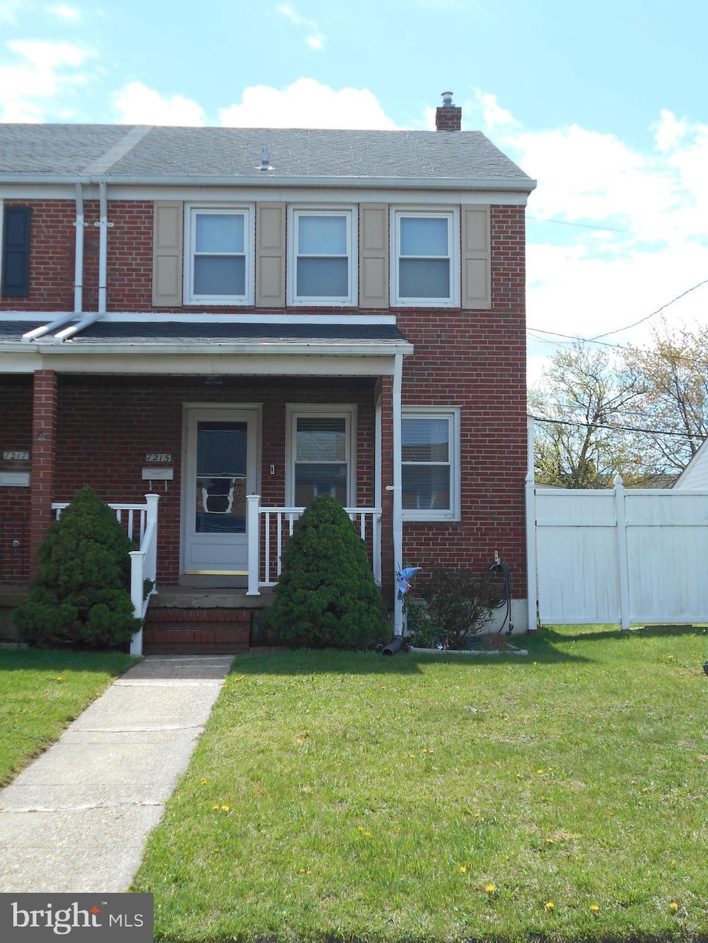 7215 Conley St, Baltimore, MD 21224 - townhome / multi-family property with brick siding, a chimney, and a porch