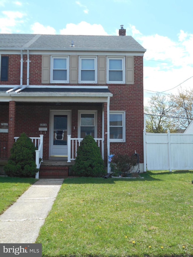 7215 Conley St, Baltimore, MD 21224 - townhome / multi-family property with brick siding, a chimney, and a porch