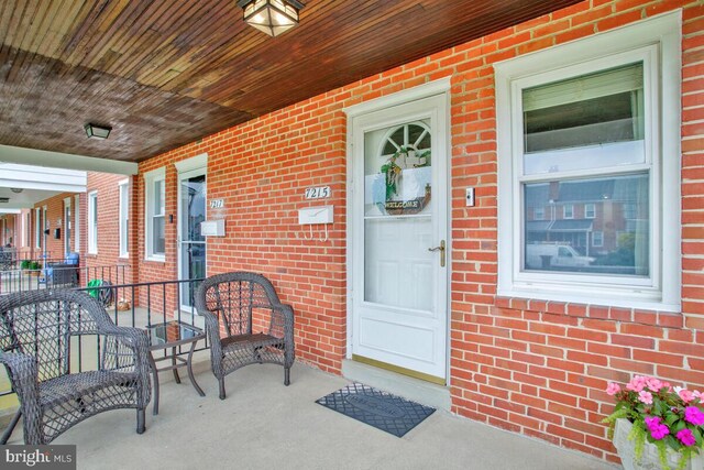 7215 Conley St, Baltimore, MD 21224 - property entrance featuring covered porch and brick siding