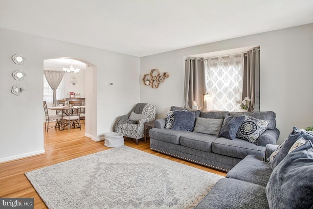7215 Conley St, Baltimore, MD 21224 - living area featuring arched walkways, healthy amount of natural light, wood finished floors, and a chandelier