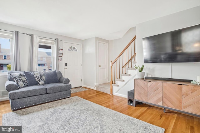 7215 Conley St, Baltimore, MD 21224 - living room featuring wood finished floors, stairs, and baseboards