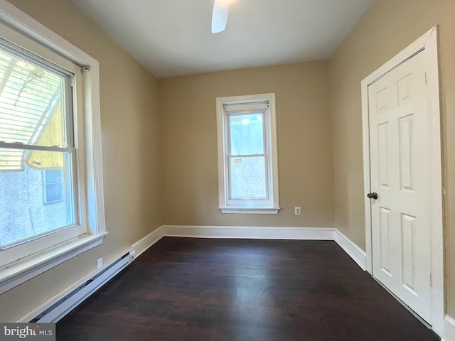 27 N 51st St, Philadelphia, PA 19139 - empty room with healthy amount of natural light, a baseboard radiator, and dark wood-style flooring
