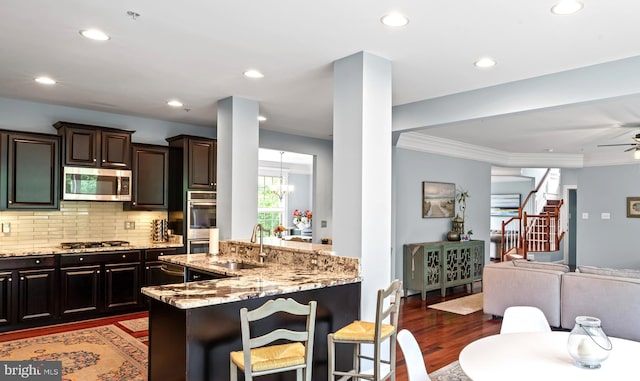 4300 Mountain Laurel Way, Brandywine, MD 20613 - kitchen with appliances with stainless steel finishes, a sink, a breakfast bar, light stone counters, and wood finished floors
