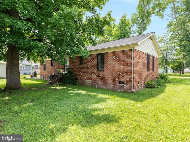 29 8th St, Colonial Beach, VA 22443 - view of side of home with crawl space, brick siding, a yard, and a shingled roof