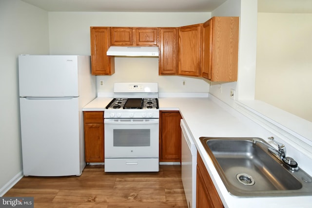 1031 Gardenview Loop Unit 103, Woodbridge, VA 22191 - kitchen with white appliances, under cabinet range hood, brown cabinetry, and wood finished floors