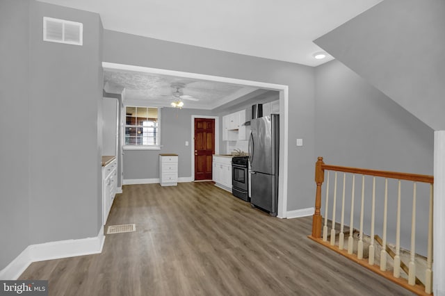 503 W 27th St, Baltimore, MD 21211 - kitchen featuring appliances with stainless steel finishes, wood finished floors, white cabinetry, baseboards, and a ceiling fan