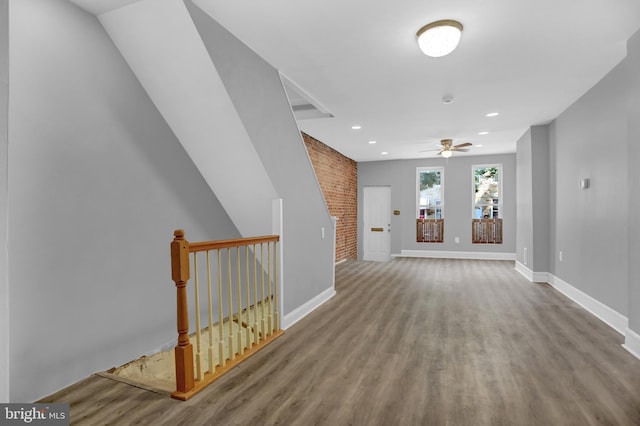 503 W 27th St, Baltimore, MD 21211 - unfurnished living room with wood finished floors, baseboards, ceiling fan, recessed lighting, and brick wall