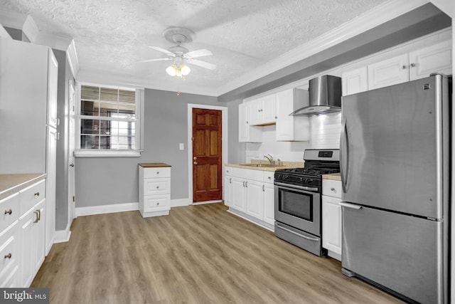 503 W 27th St, Baltimore, MD 21211 - kitchen with stainless steel appliances, wall chimney exhaust hood, light countertops, a textured ceiling, and white cabinetry