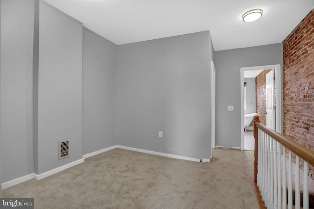 503 W 27th St, Baltimore, MD 21211 - unfurnished room featuring brick wall, carpet flooring, and baseboards