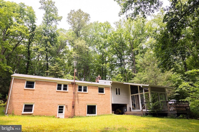 2720 Hidden Valley Rd, Accokeek, MD 20607 - rear view of house with a lawn, a wooden deck, brick siding, a chimney, and view of scattered trees