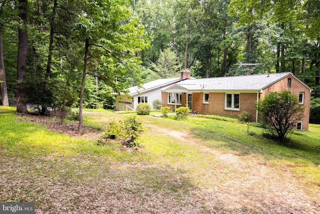 2720 Hidden Valley Rd, Accokeek, MD 20607 - view of front of property featuring brick siding, an attached garage, a chimney, and a front lawn