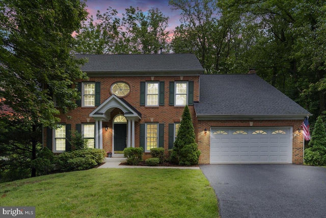 1381 Sunwood Ter, Annapolis, MD 21409 - georgian-style home with driveway, an attached garage, brick siding, a front yard, and a shingled roof