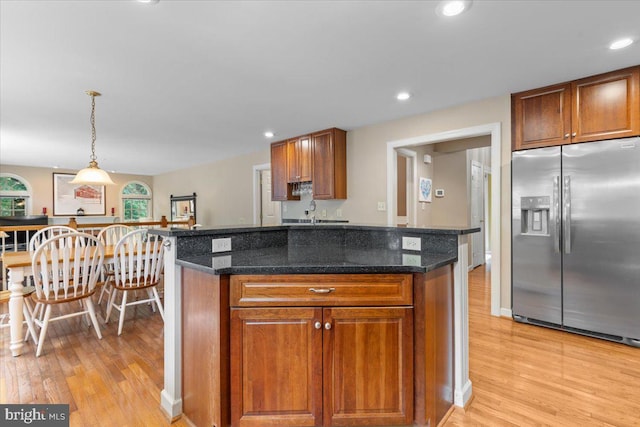1381 Sunwood Ter, Annapolis, MD 21409 - kitchen with stainless steel fridge, light wood-style floors, brown cabinets, decorative light fixtures, and recessed lighting