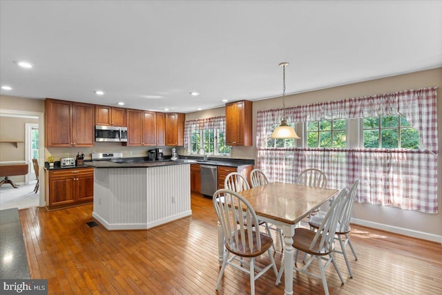 1381 Sunwood Ter, Annapolis, MD 21409 - kitchen with appliances with stainless steel finishes, dark countertops, brown cabinets, light wood-style flooring, and recessed lighting