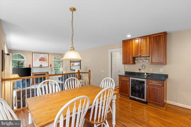 1381 Sunwood Ter, Annapolis, MD 21409 - dining room featuring wine cooler, bar with sink, light wood finished floors, baseboards, and a brick fireplace