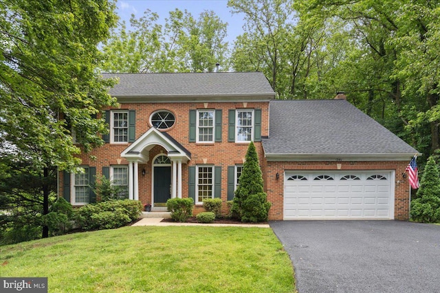 1381 Sunwood Ter, Annapolis, MD 21409 - view of front facade featuring driveway, an attached garage, brick siding, a chimney, and a shingled roof