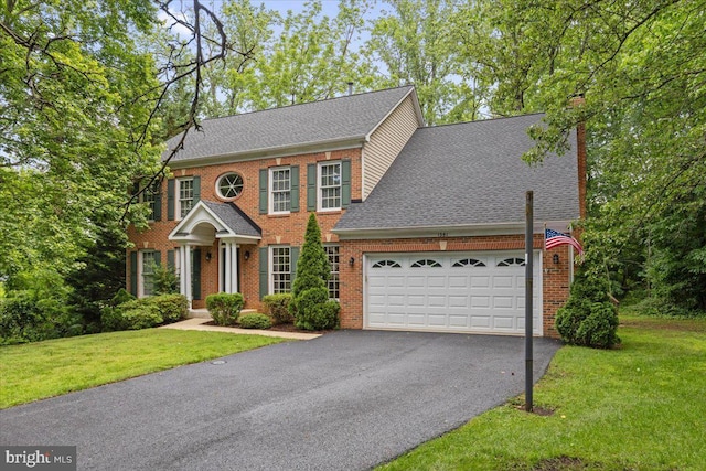 1381 Sunwood Ter, Annapolis, MD 21409 - georgian-style home with an attached garage, brick siding, asphalt driveway, a chimney, and a front yard