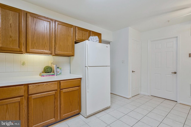 2615 Rigging Dr Unit 2615, Annapolis, MD 21401 - kitchen featuring freestanding refrigerator, brown cabinetry, decorative backsplash, and light countertops