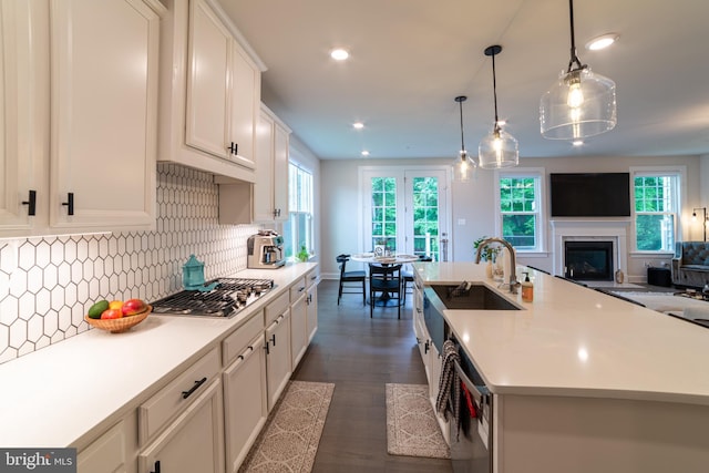 233 W Ponds Edge Dr, Media, PA 19063 - kitchen featuring stainless steel gas stovetop, open floor plan, light countertops, a glass covered fireplace, and white cabinetry